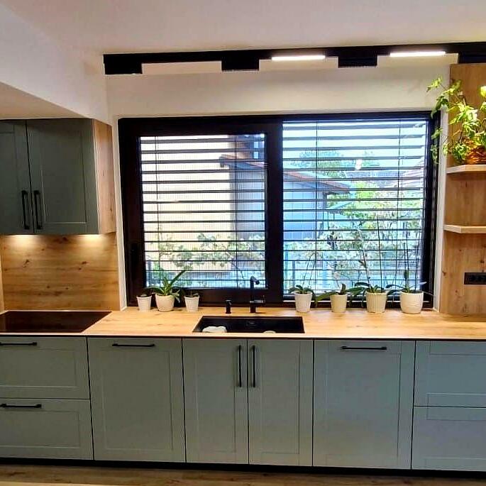 Kuhinja koja se proteže cijelom dužinom, spajajući funkcionalnost i estetiku. Istaknuti stakleni element s integriranom LED rasvjetom dodaje profinjenost i moderni vizualni dojam, stvarajući elegantan ambijent.